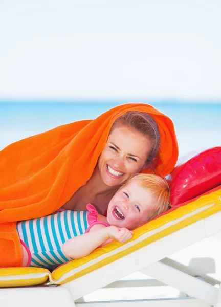 Retrato de la madre sonriente y el bebé tumbado en la cama solar — Foto de Stock