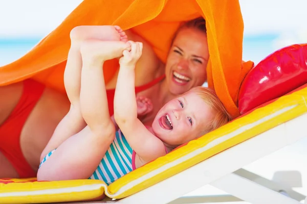 Porträt einer lächelnden Mutter mit Baby auf Chaiselongue — Stockfoto