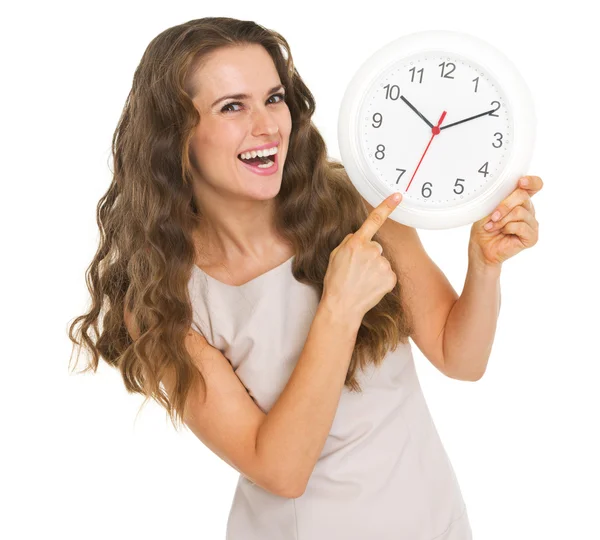 Smiling young woman pointing on clock Royalty Free Stock Photos