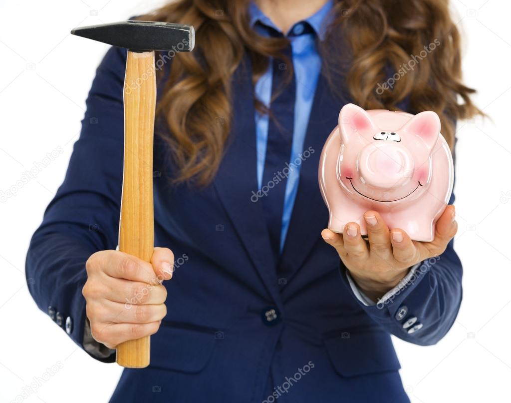 Closeup on business woman giving piggy bank and hammer