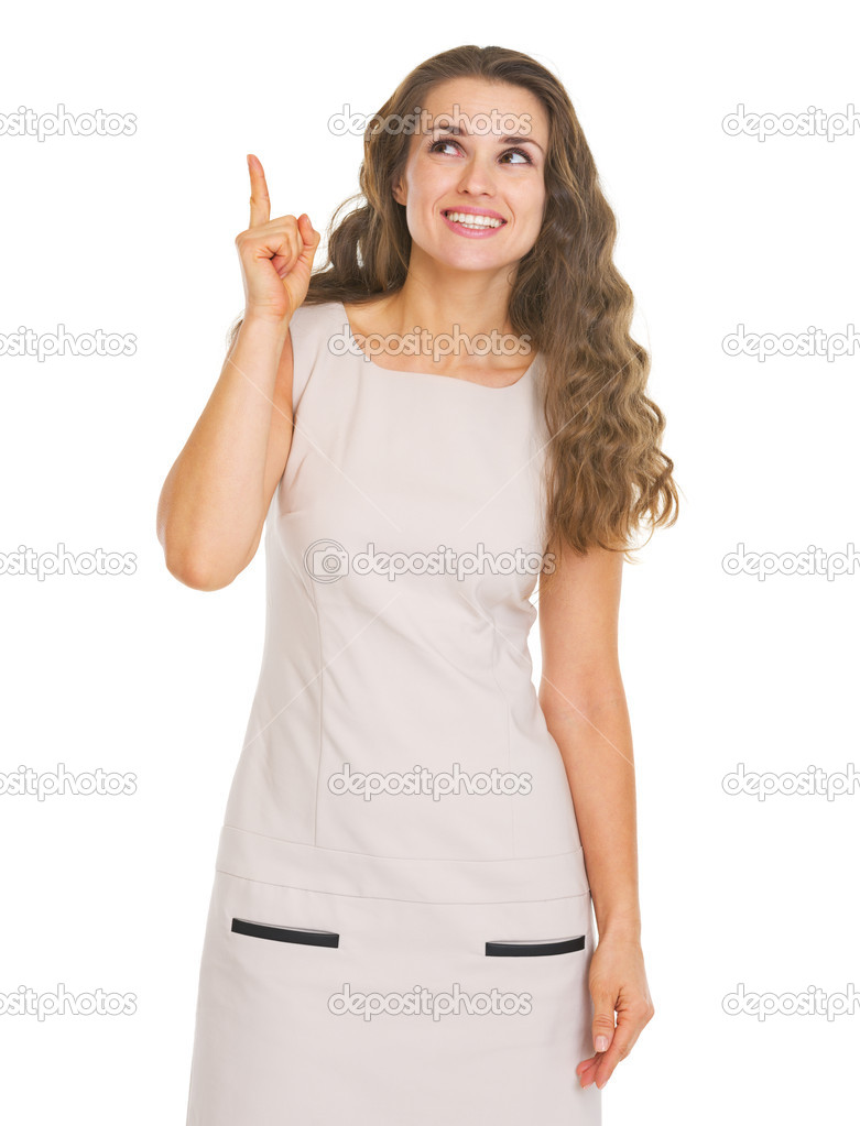 Happy young woman pointing up on copy space