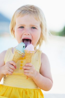 Happy baby eating two ice cream