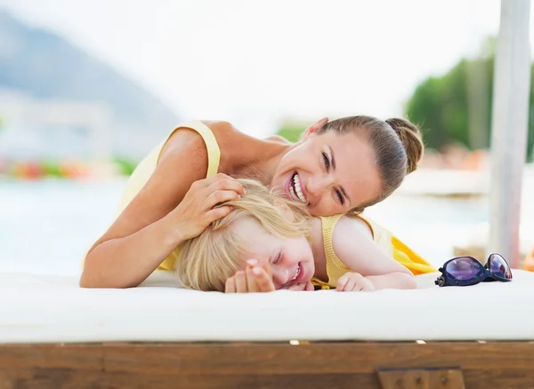 Gelukkig moeder en baby spelen bij zwembad — Stockfoto