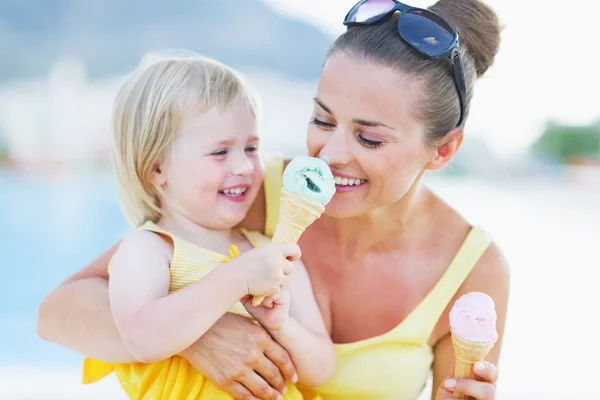 Smiling baby giving mother ice cream — Stock Photo, Image