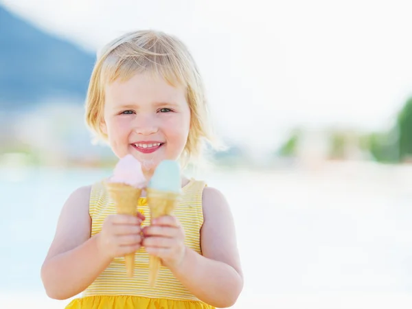 Bambino sorridente che mangia due corna gelato — Foto Stock