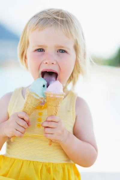 Onnellinen vauva syö kaksi jäätelöä — kuvapankkivalokuva