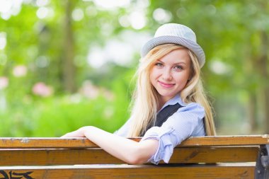 Kent parkta bankta oturan hipster kız