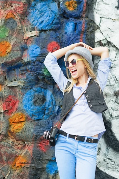 Chica hipster feliz mirando en el espacio de copia contra la pared urbana —  Fotos de Stock