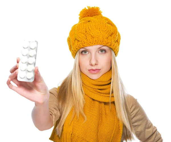 Chica seria en bufanda y sombrero mostrando blister paquete de pastillas —  Fotos de Stock