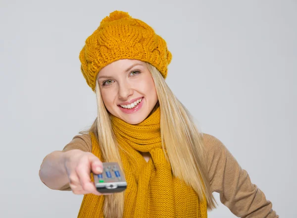 Gelukkig meisje in sjaal en muts met tv-afstandsbediening — Stockfoto