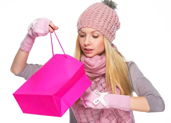 Curious girl in winter clothes looking into shopping bag — Stock Photo, Image