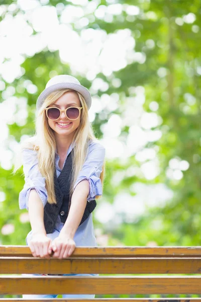 Hipster meisje, zittend op de Bank in het stadspark — Stockfoto