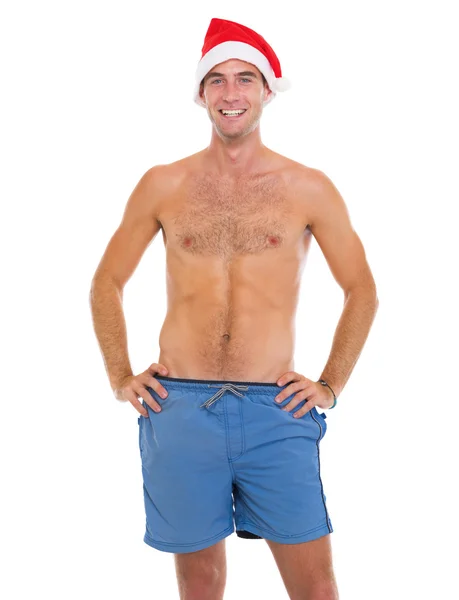 Smiling man in beach shorts and santa hat — Stock Photo, Image