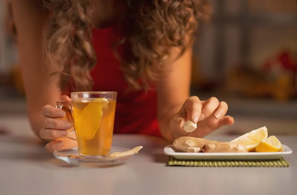 Gros plan sur la jeune femme en ajoutant du sucre de canne cube dans le thé au gingembre — Photo