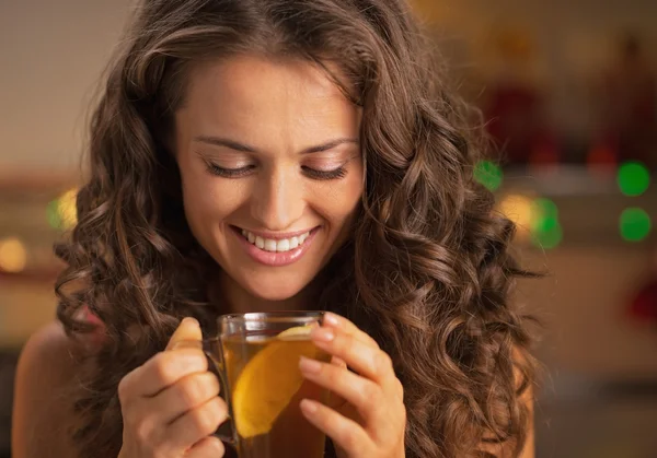 Feliz joven disfrutando bebiendo té de jengibre con limón —  Fotos de Stock