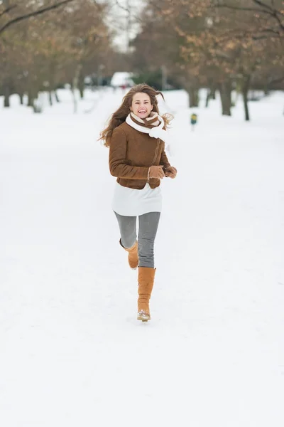Счастливая молодая женщина бегает в зимнем парке — стоковое фото
