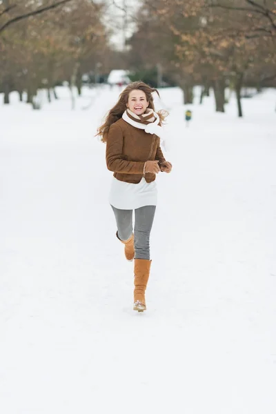 Felice giovane donna in esecuzione nel parco invernale — Foto Stock