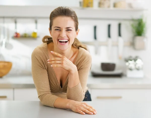 Retrato de sorrir jovem dona de casa na cozinha moderna — Fotografia de Stock