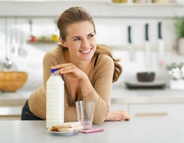 Doordachte jonge vrouw met scherpe brood en melk — Stockfoto