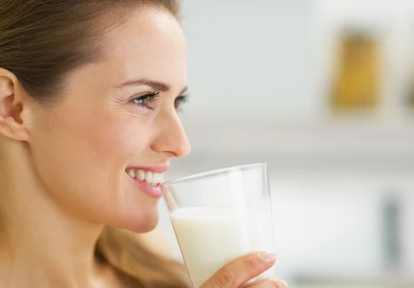 Happy young housewife drinking milk — Stock Photo, Image