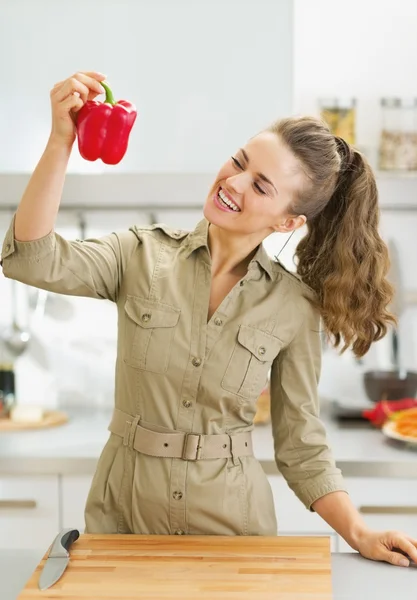 Jovem dona de casa feliz segurando pimentão vermelho — Fotografia de Stock