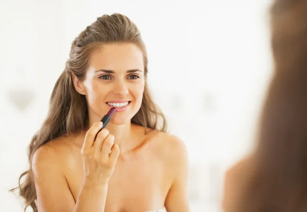 Vrouw met behulp van lippenstift — Stockfoto