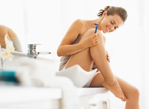 Happy woman checking legs after shaving — Stock Photo, Image