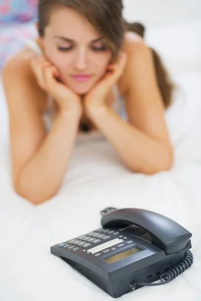 Nahaufnahme am Telefon und Warten auf Anruf junge Frau im Hintergrund — Stockfoto