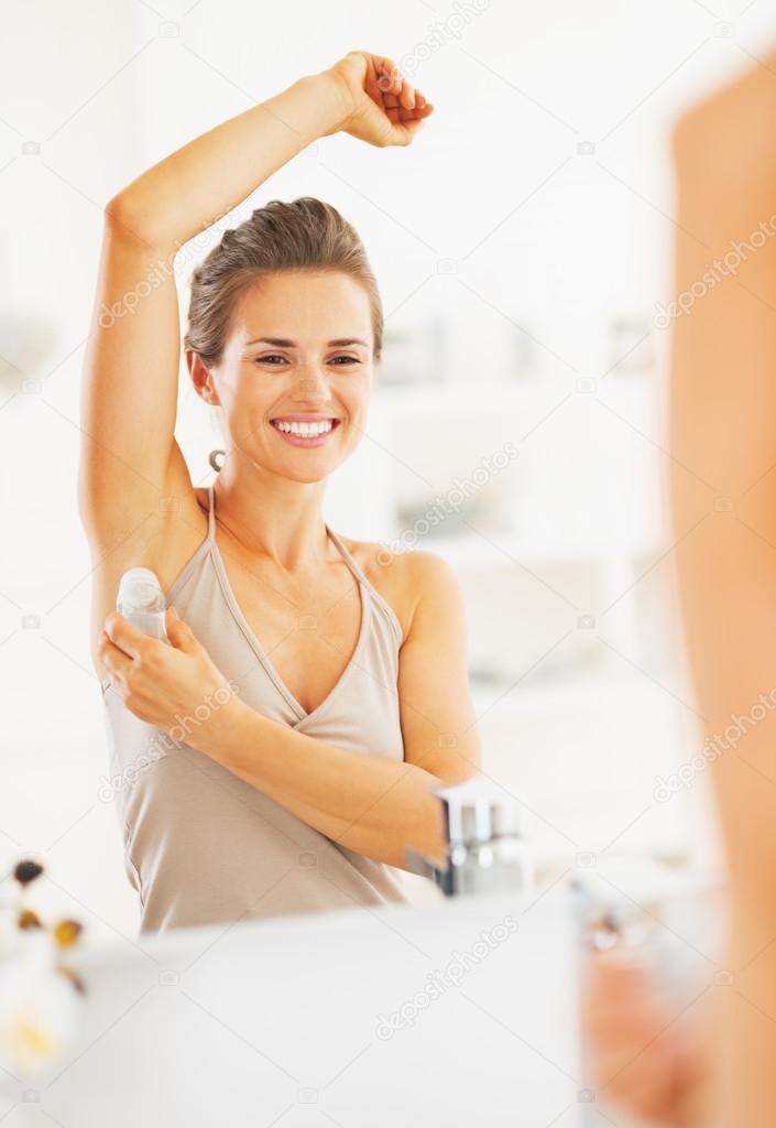 Woman applying roller deodorant