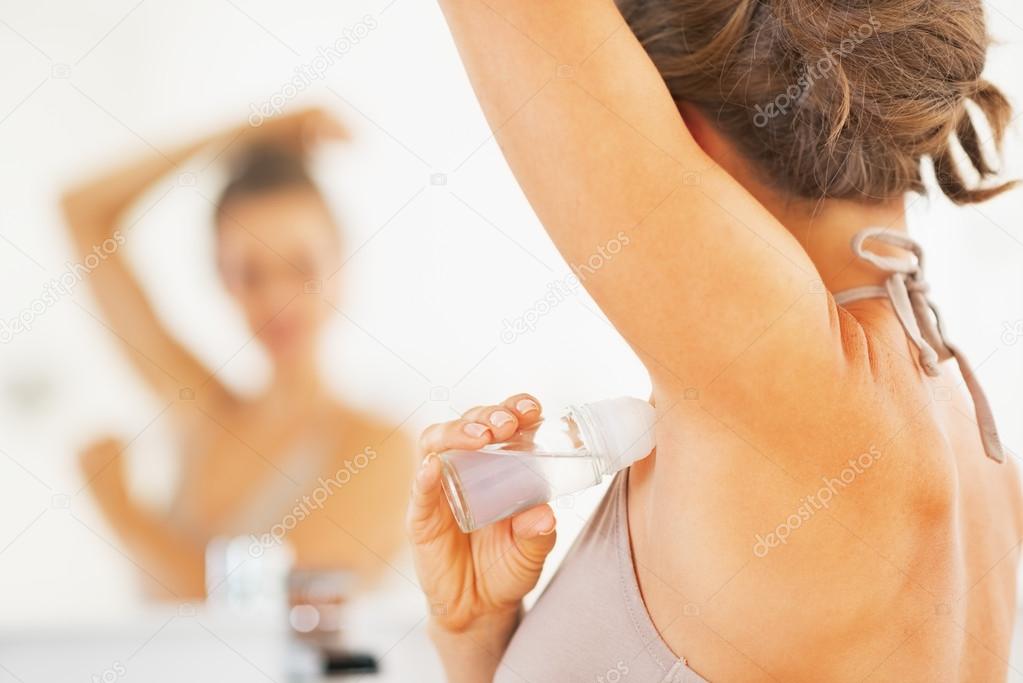 Woman applying roller deodorant