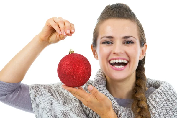 Glückliche junge Frau im Pullover zeigt Weihnachtskugel — Stockfoto