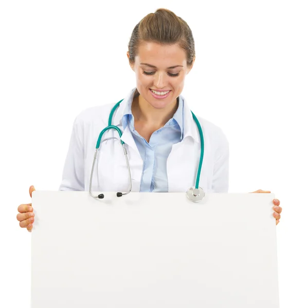 Mujer doctora feliz mirando en la cartelera en blanco —  Fotos de Stock