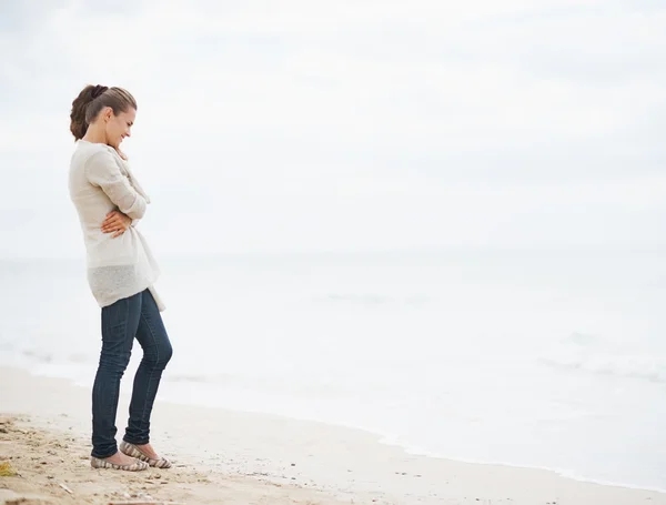 Frau im Pullover am einsamen Strand — Stockfoto