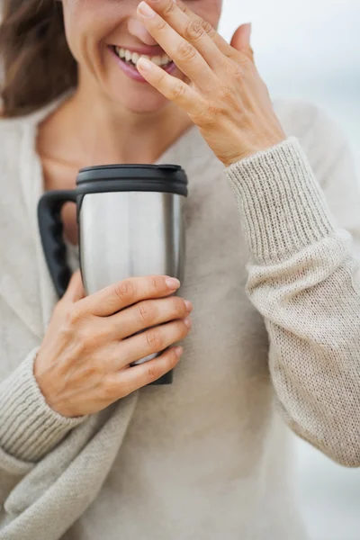 Frau im Pullover am Strand mit Tasse — Stockfoto