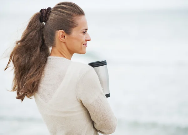 Donna in maglione sulla spiaggia con coppa — Foto Stock