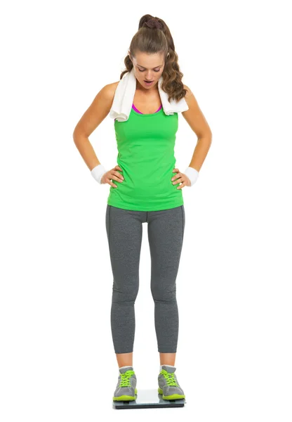 Překvapený fitness mladá žena stojící na váhy — Stock fotografie
