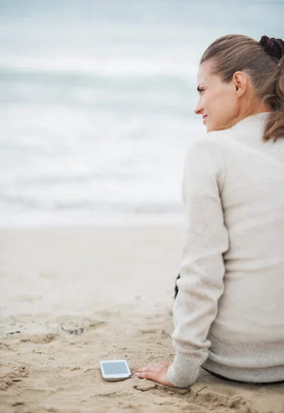 ผู้หญิงในสเวตเตอร์บนชายหาดที่โดดเดี่ยว — ภาพถ่ายสต็อก