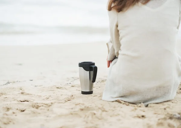 Žena v svetr na pláži s cup — Stock fotografie