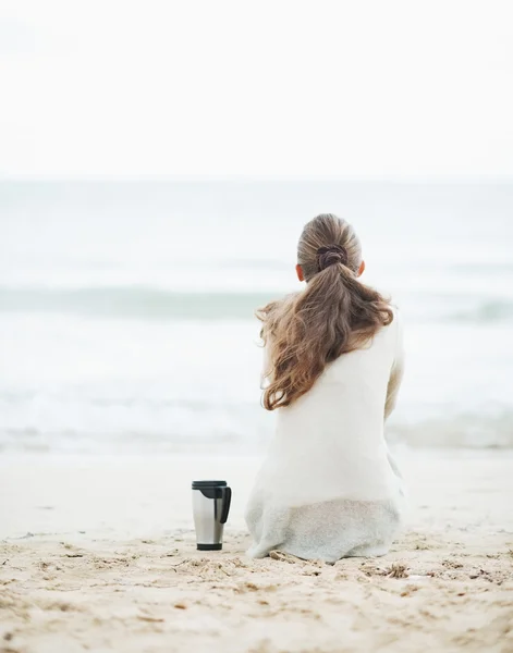 Femme en pull sur la plage avec tasse — Photo