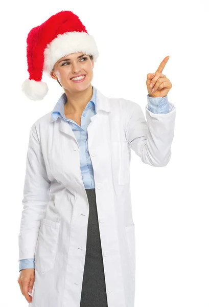 Lachende vrouw van de dokter in Kerstman hoed wijzen op kopie ruimte — Stockfoto
