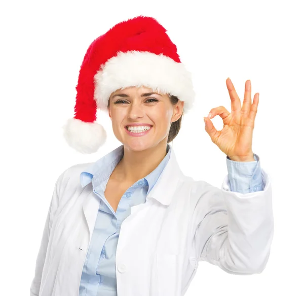 Feliz médico mujer en sombrero de santa mostrando gesto ok — Foto de Stock