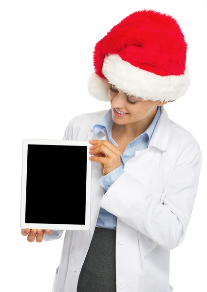 Heureuse femme médecin dans le chapeau de Père Noël montrant comprimé PC écran vide — Photo