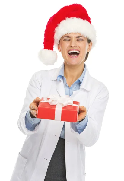 Feliz médico mulher em santa chapéu dando natal presente caixa — Fotografia de Stock