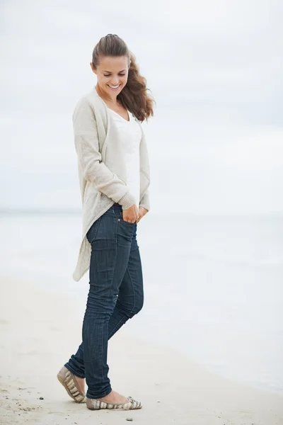 Glückliche junge Frau im Pullover genießt einsamen Strand — Stockfoto