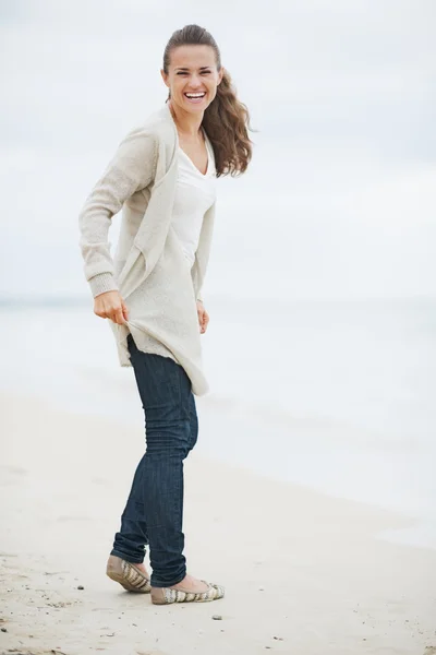 Szczęśliwa młoda kobieta w sweter spaceru na plaży samotny — Zdjęcie stockowe