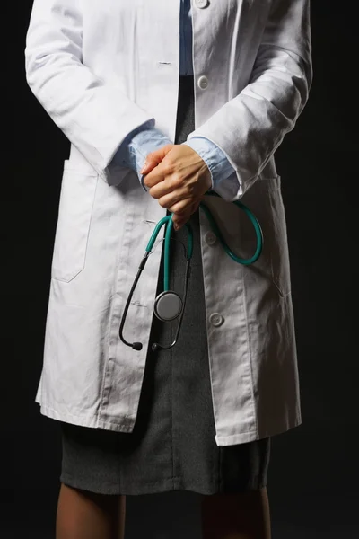 Closeup on stethoscope in hand of doctor woman isolated on black — Stock Photo, Image