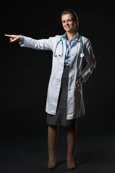 Full length portrait of smiling doctor woman pointing on copy sp — Stock Photo, Image