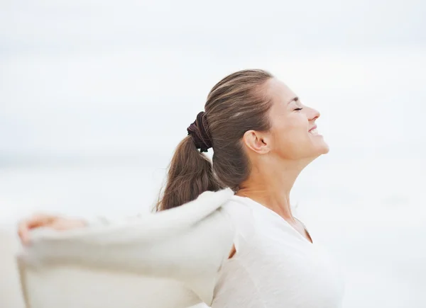 Glückliche junge Frau im Pullover am einsamen Strand jubelt — Stockfoto