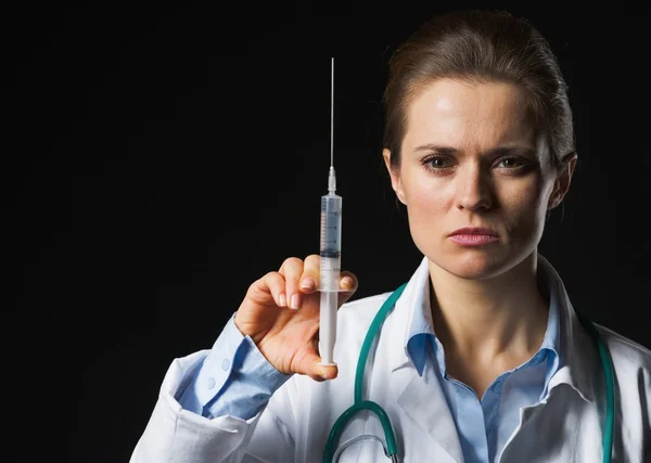 Serious doctor woman with syringe isolated on black — Stock Photo, Image