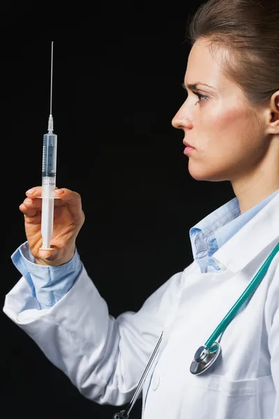 Médecin femme avec seringue sur fond noir — Photo